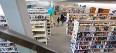 Photo of child and caregiver walking through the Grande Prairie Public Library
